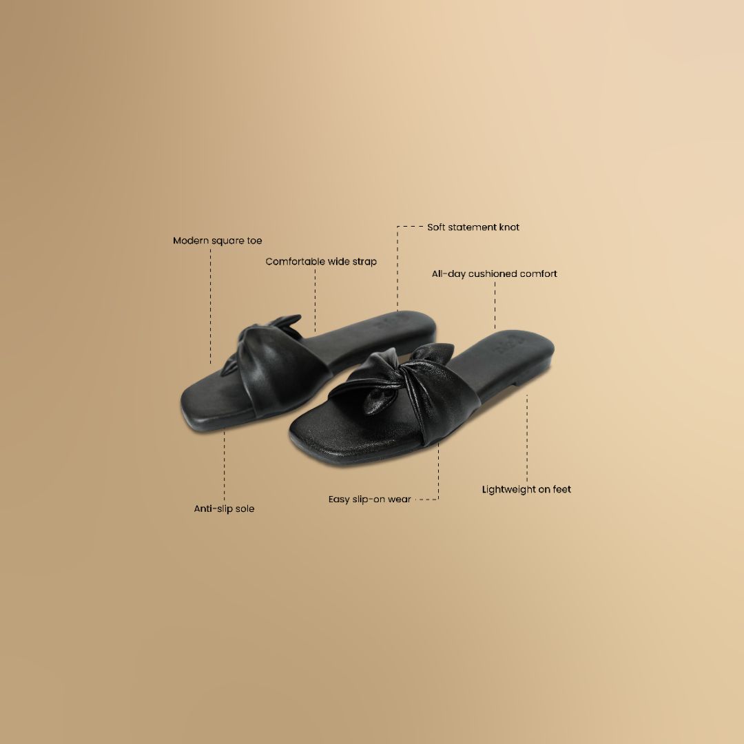 Black sandals with bow details on a beige background