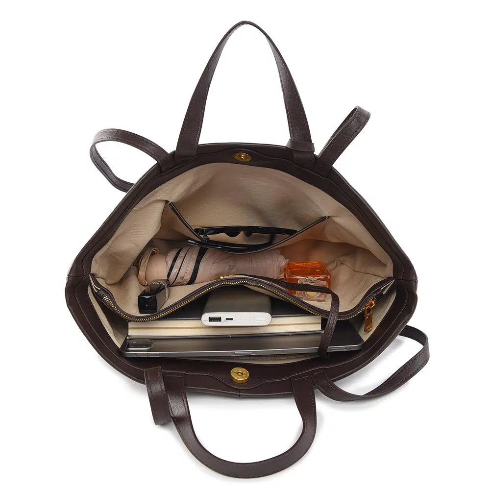 Brown leather handbag with interior items on a white background